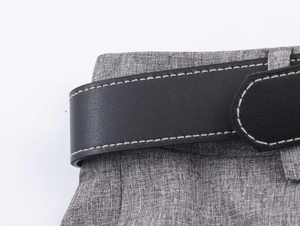 Close-up of black leather belt and textured grey herringbone suit trousers waistband