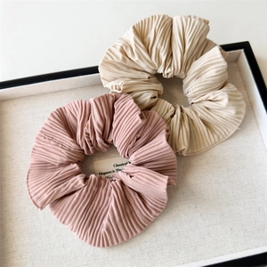 Dettaglio degli elastici scrunchie in raso pieghettato rosa e beige effetto seta