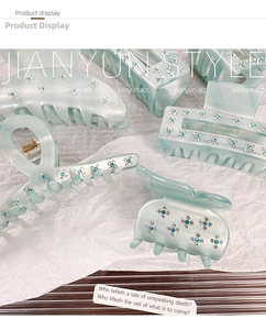 Detailed view of light blue acetate hair claws featuring delicate blue rhinestone flowers
