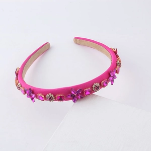 Detailed view of luxury pink headband with purple rhinestones and crystal flower accents