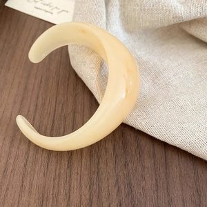 Detailed view of cream resin open cuff bracelet with minimalist smooth finish and texture