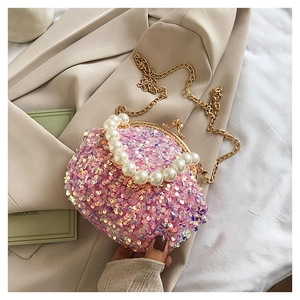 Detailed close-up of pink sequin mini bag with pearl handle and gold chain strap