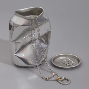Artistic close-up of mixed-metal soda tab pendant necklace with textured finish