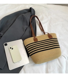 Confronto dimensioni borsa grande in paglia con iPad e cellulare su letto