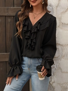 Elegante blusa de gasa negra con cuello en V y volantes en una toma exterior de estilo