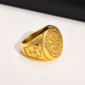Vue macro d'une bague aigle dorée avec boussole viking gravée et nœuds celtiques