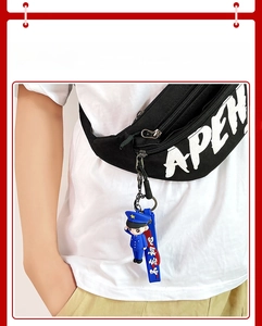 Detailed view of cartoon soldier keychain on a black bag with navy silicone strap