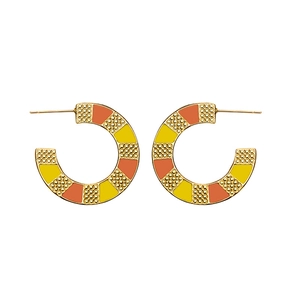 Detailed macro view of gold-plated C-shape hoop earrings with orange checkerboard enamel