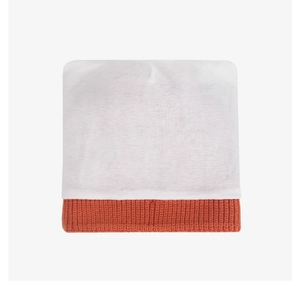 Détail d'un bonnet en tricot pour enfants avec haut blanc et bord côtelé orange vif