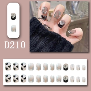 Detail of press-on nails with black hearts, pearl relief, and silver marble art D210