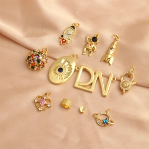 18K gold plated celestial charms including astronauts and rockets on silk fabric