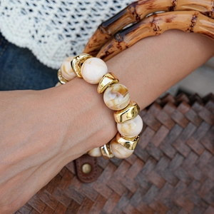 Close-up of bohemian resin marble beads and gold metallic spacers on a wrist