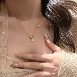 Elegant gold clover pendant necklace set with sparkling crystals and a matching ring