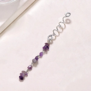 Detailed shot of silver spiral hair coil with natural purple amethyst stone pendant