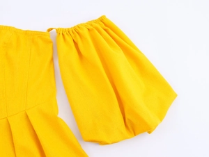 Close-up of yellow puff sleeves with elastic cuffs and detailed stitching on dress