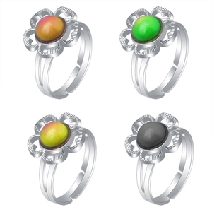 Detailed view of four adjustable color-changing gemstone rings in silver-tone metal