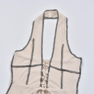 Détail du haut dos nu beige à fines côtes avec lacets croisés et coutures contrastées noires
