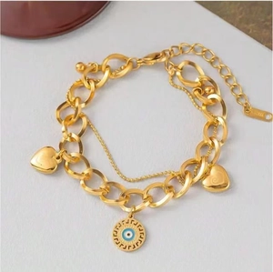 Vue détaillée du bracelet double couche doré en acier avec pendentifs cœur et œil grec