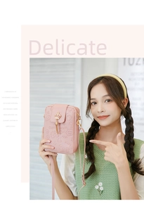 Detail of pink embossed crossbody phone bag with golden crown and heart patterns