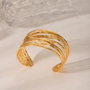 Vue détaillée du bracelet manchette large ajouré aux lignes dorées irrégulières