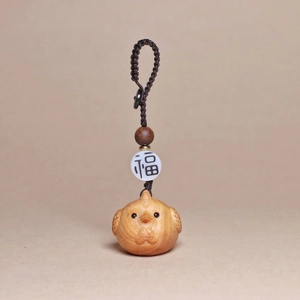 Detail of hand-carved wooden rooster pendant with lucky charm bead and brown braided cord