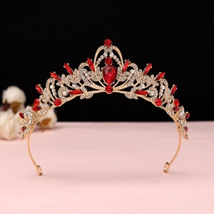 Close-up of golden Baroque bridal crown with red gemstones and intricate crystal details