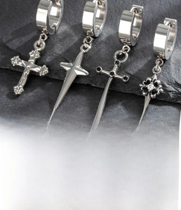 Macro detail of four silver titanium steel cross and sword pendant earrings with zircons