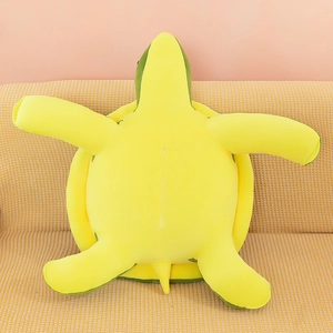 Cute green and yellow plush sea turtle doll with zipper detail on a cozy yellow sofa