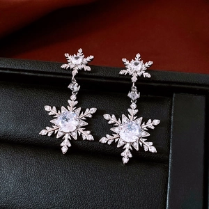 Macro view of silver snowflake earrings with sparkling crystals in a black jewelry box