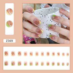 Detail of pink gradient press-on nails with yellow and green tips and rhinestones