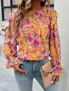Detail of yellow long sleeve floral shirt with ruffles and feminine flower patterns
