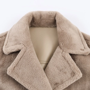 Close-up of khaki faux shearling and leather splicing on a reversible warm jacket