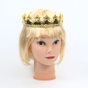 Detail of a gold king crown for kids cake topper with orange gemstones on a mannequin head
