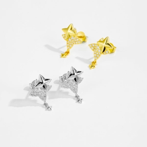 Detailed view of silver and gold star stud earrings with sparkling cubic zirconia inlay