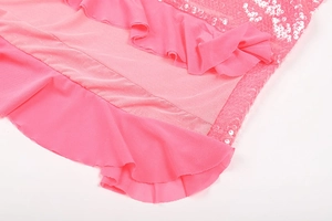 Detail of pink sequin dress showing ruffle mesh trim and sparkling fabric textures