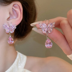 Detailed view of pink crystal butterfly earrings with teardrop pendant in silver finish