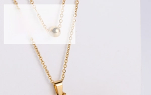 Close-up of gold-plated titanium steel jewelry set with butterfly pendant and ball earrings