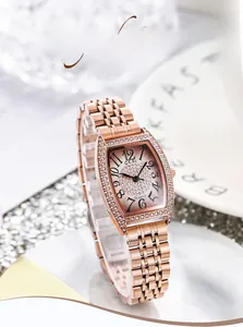 Gros plan d'une montre tonneau en or rose avec cadran pavé de cristaux et chiffres