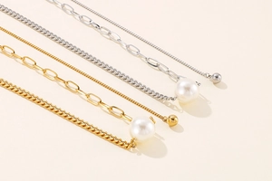Detail of gold and silver cuban and paperclip chains with white pearl accents