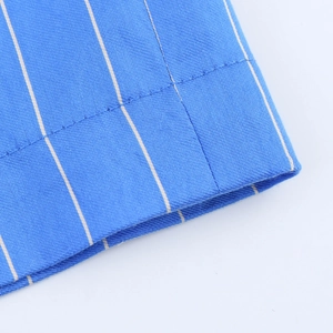 Detail of blue and white vertical striped fabric with neat double stitching on the hem