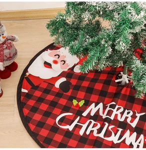 Detail of red and black plaid Christmas tree skirt with Santa Claus and Merry Christmas text