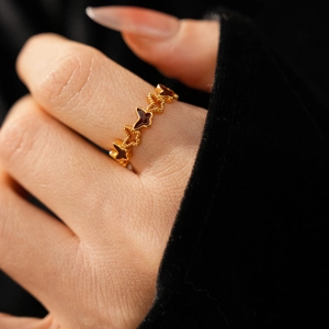 Detailed close-up of 18k gold-plated ring with red enamel butterfly design