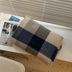 Detail of blue and beige plaid scarf texture with soft fringe and knit pattern