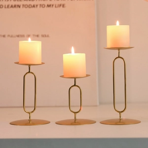 Three-piece modern gold metal candlestick set in varying heights for elegant home decor