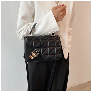 Détail du sac à bandoulière matelassé noir avec boucle dorée et bandoulière en chaîne