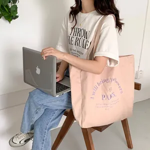 Detailed view of a pink canvas tote bag with purple letter embroidery for daily use.