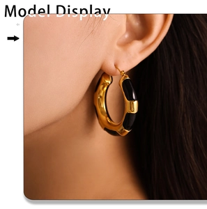Close-up of model wearing gold and black leopard enamel hoop earrings in stainless steel