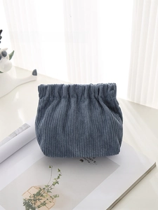 Detailed close-up of blue corduroy texture and gathered closure on a mini pouch