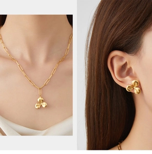 Detailed view of gold flower necklace and matching earrings set on a model