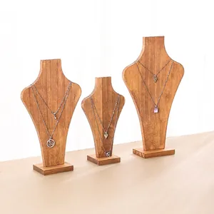 Three-piece set of minimalist wooden bust necklace stands with natural grain texture